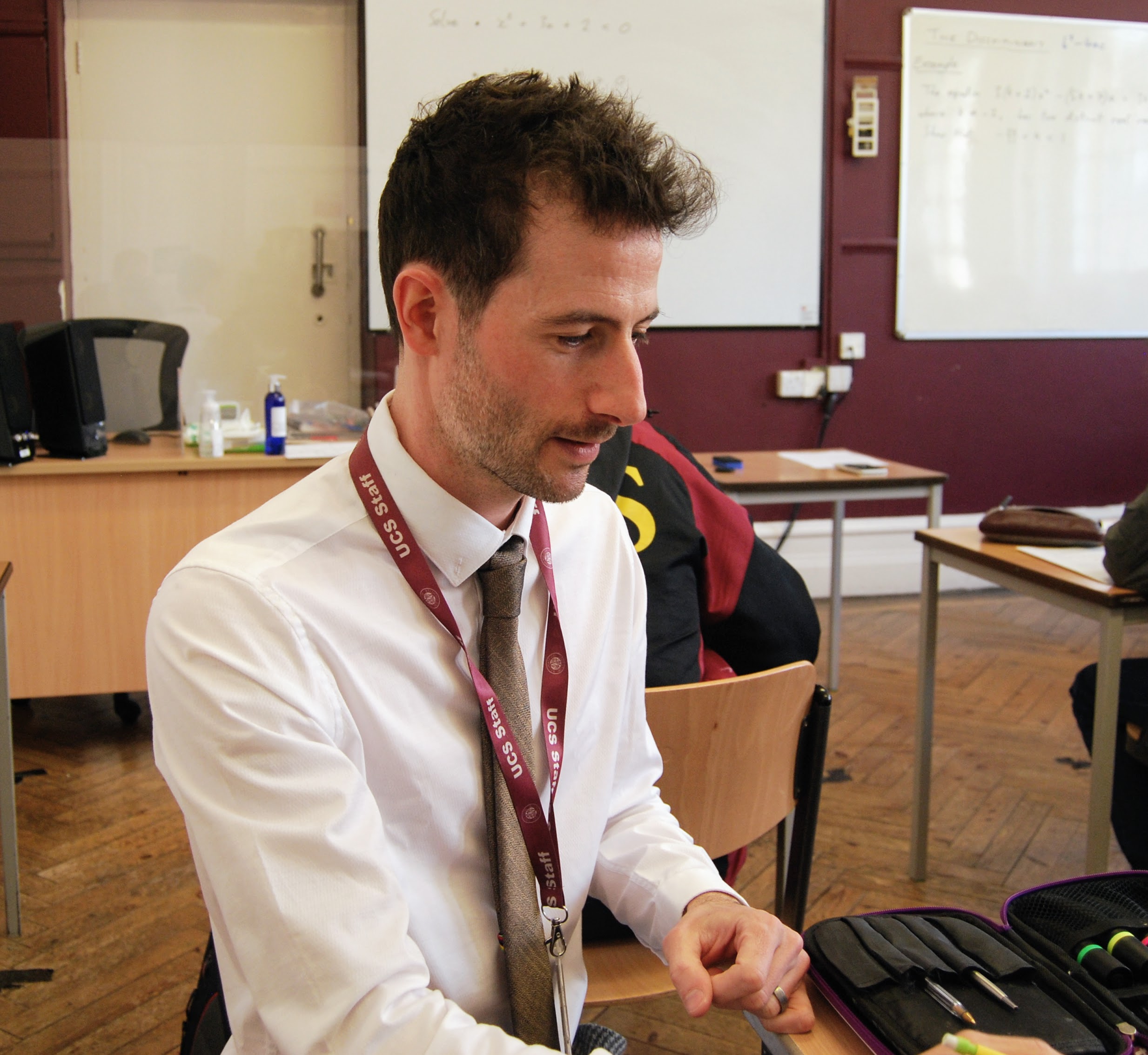 Micky Bullock teaching at a pupil's desk